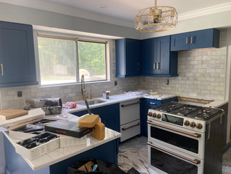 A kitchen with blue cabinets and white counter tops, creating a modern and fresh look.