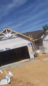 A house under construction with an open garage door.