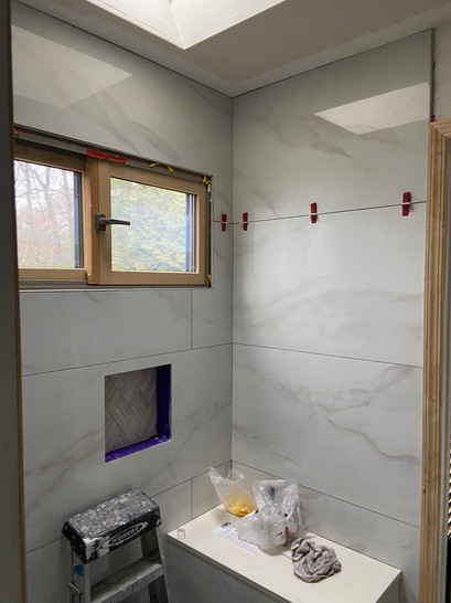 A bathroom with a window and a shower, featuring modern fixtures and natural light.