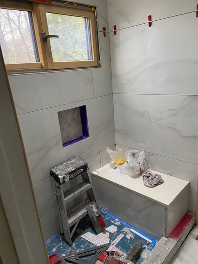 A bathroom with a shower and a bench, providing comfort and convenience for users.